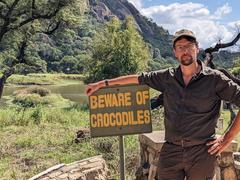 Christoph Borgans steht in Afrika neben einem Schild mit der Aufschrift 'Beware of Crocodiles'. (Foto: SR/Christoph Borgans)